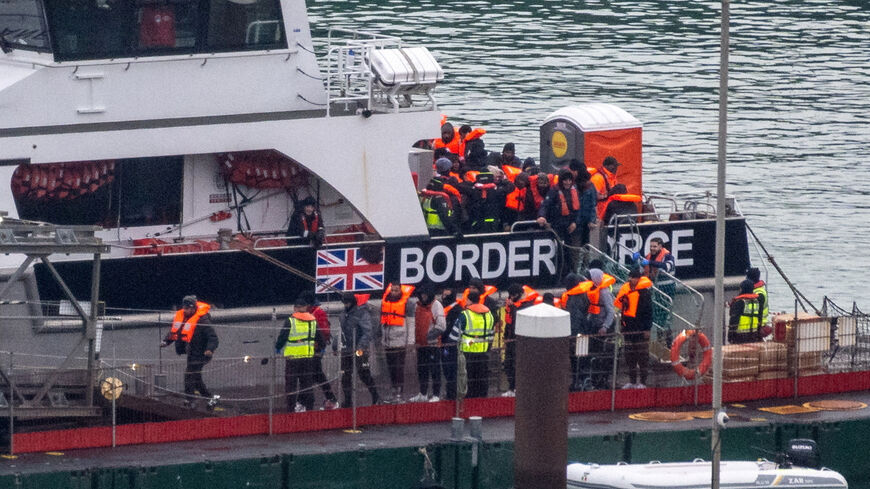 FILE PHOTO: Migrants disembark from a British Border Force vessel as they arrive at the Port of Dover, in Dover, Britain, December 29, 2024. REUTERS/Chris J. Ratcliffe/File Photo