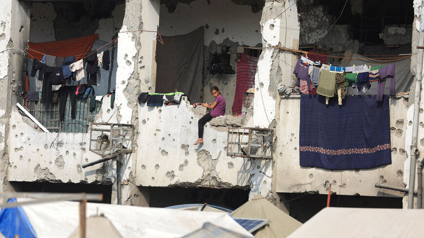 A displaced Palestinian girl sits on a wall of a damaged school where she has taken shelter in Gaza City, November 11. REUTERS/Dawoud Abu Alkas