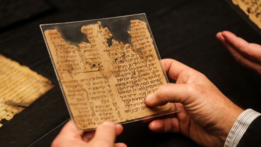 A researcher of MiDRASH, a project dedicated to analysing the National Library of Israel’s digital database of all known Hebrew manuscripts using Machine Learning, including manuscripts from the Cairo Geniza, holds fragments of an aggadic-midrashic work of Torah exegesis and retellings of biblical stories, in Jerusalem November 24, 2025. REUTERS/Ronen Zvulun
