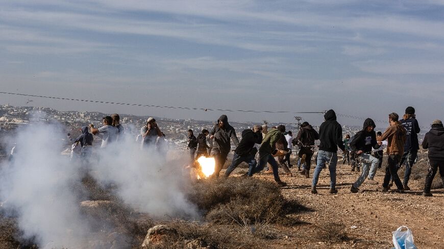 Hilltop Youth members run for cover as they clash with Israeli security forces evacuating and demolishing the illegal outpost
