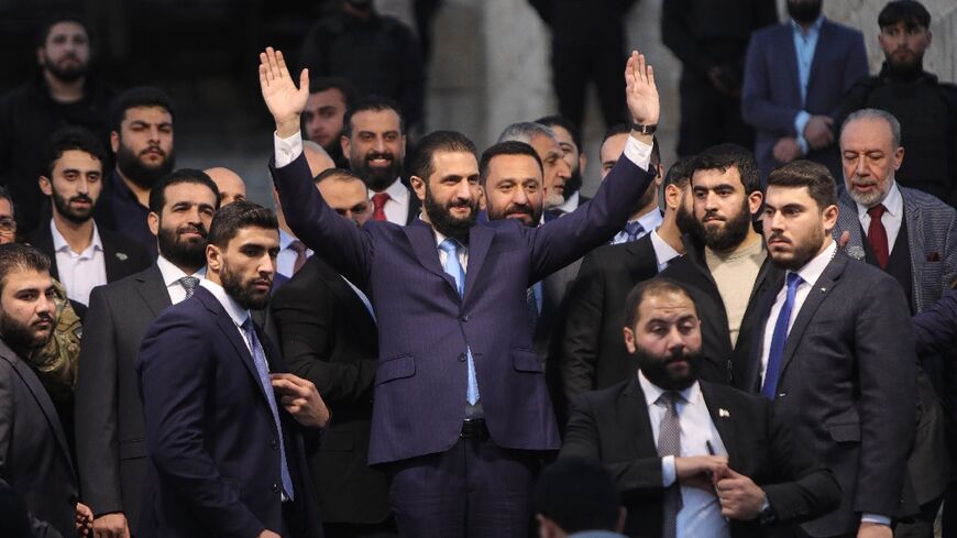 Syrian President Ahmed al-Sharaa waves to the crowd at the gate of Aleppo's citadel