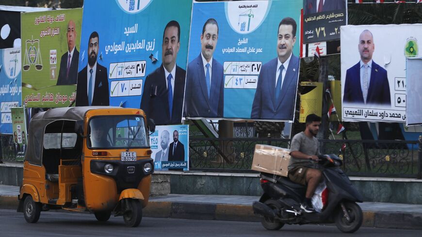 People drive past election billboards in Baghdad, Oct. 14, 2025. 