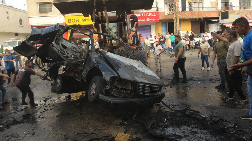 A bulldozer removes the wreckage of a vehicle targeted by an Israeli drone strike in the southern Lebanese village of Doueir near the city of Nabatieh, on Nov. 3, 2025. 