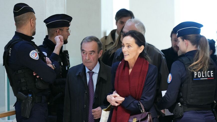 Former Director General of Lafarge Bruno Lafont (C) and French lawyer Jacqueline Laffont arrive on the opening day of the trial.
