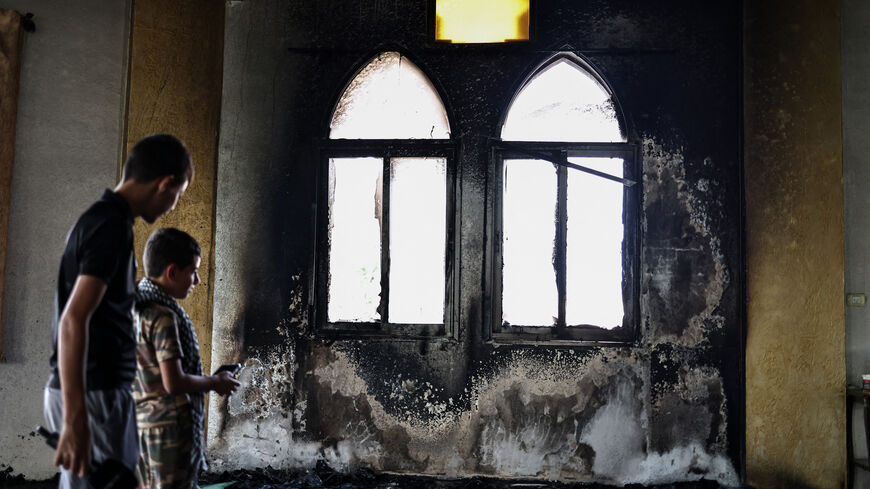 Young Palestinians look at the damage in the Hajja Hamida Mosque after it was reportedly set on fire and vandalised by Israeli settlers in the Palestinian village of Deir Istiya, near Salfit in the Israeli-occupied West Bank, on November 13, 2025. Violence in the West Bank has soared since the war in Gaza broke out in October 2023. (Photo by Zain JAAFAR / AFP) (Photo by ZAIN JAAFAR/AFP via Getty Images)