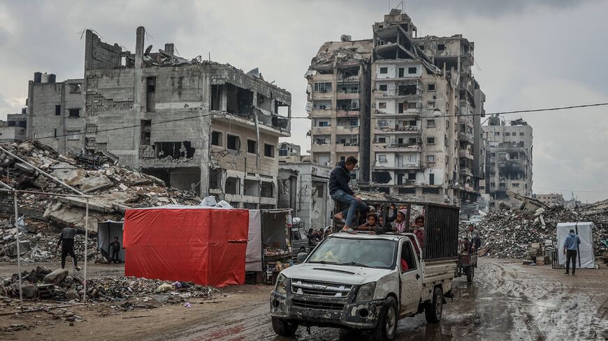 Palestinians drive down a muddy road after the first winter rainfall on a displacement camp in Gaza City on Nov. 14, 2025. 