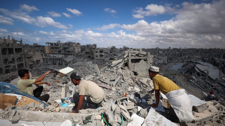 Palestinians search the rubble of buildings in Khan Yunis in the southern Gaza Strip