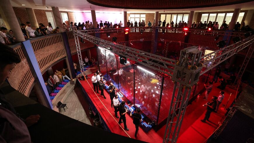 Engineering students and guests watch robots battle it out at Iran's Tech Olympics