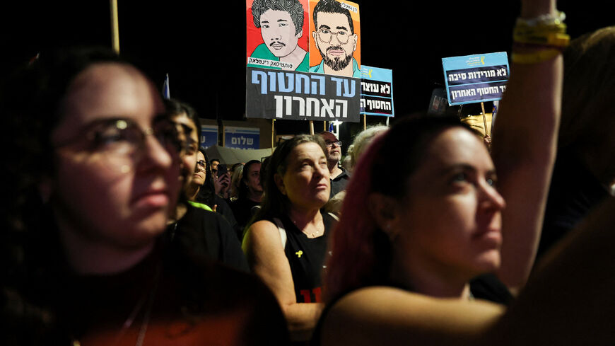 People hold images of dead hostages Ran Gvili and Sudthisak Rinthalak, whose bodies haven’t been returned yet, as Israelis attend a rally calling for the immediate return of the remains of all hostages held in Gaza, more than two years after the deadly October 7, 2023, attack on Israel by Hamas, at the Hostages Square in Tel Aviv, Israel, November 29, 2025. REUTERS/Nir Elias