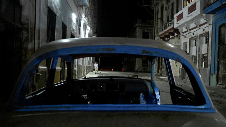 FILE PHOTO: A man walks down a street after power was restored following a partial collapse of the electrical grid that left much of western Cuba in the dark, in Havana, Cuba, December 3, 2025. REUTERS/Norlys Perez/File Photo