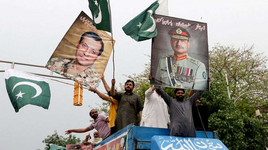 FILE PHOTO: People carry posters showing the pictures of Chief of Army Staff of Pakistan Asim Munir, (R) along with Ahmed Sharif Chaudhry, Director General of Inter-Service Public Relations wing of Pakistan Armed Forces, as they take part in a rally in support of Pakistan Army, day after the ceasefire announcement between India and Pakistan, in Lahore, Pakistan, May 11, 2025. REUTERS/Mohsin Raza/File Photo