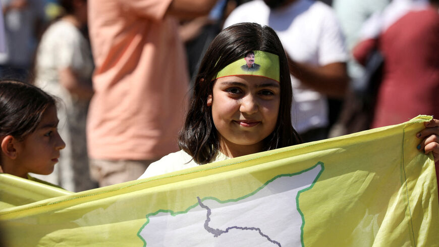 FILE PHOTO: A girl holds a Syrian Democratic Forces (SDF) flag during a demonstration under the slogan "With our will, we will protect our revolution”, in Qamishli, Syria September 17, 2025. REUTERS/Orhan Qereman/File Photo