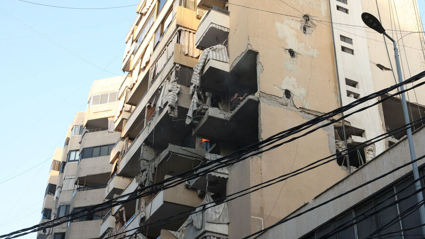 People inspect a damaged building, after Israeli military said on Sunday that it struck a militant from the Lebanese Iran-aligned Hezbollah group, in Beirut's southern suburbs, Lebanon November 23, 2025. REUTERS/Mohamed Azakir