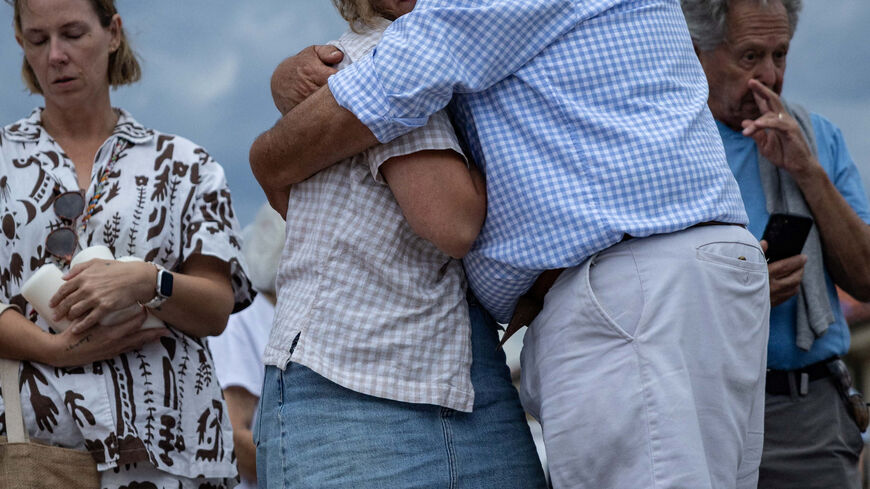 People mourn at the floral tributes for victims and survivors of a deadly mass shooting during a Jewish Hanukkah celebration at Bondi Beach on December 14, in Sydney, Australia, December 21, 2025. REUTERS/Eloisa Lopez