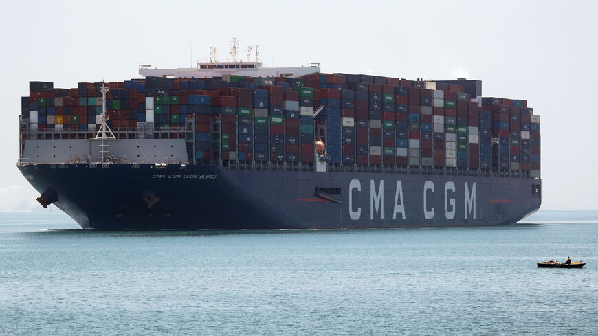 A fisherman travels on a boat in front of a CMA CGM container ship passing through the Suez Canal in Ismailia, Egypt July 7, 2021. Picture taken July 7, 2021. REUTERS/Amr Abdallah Dalsh