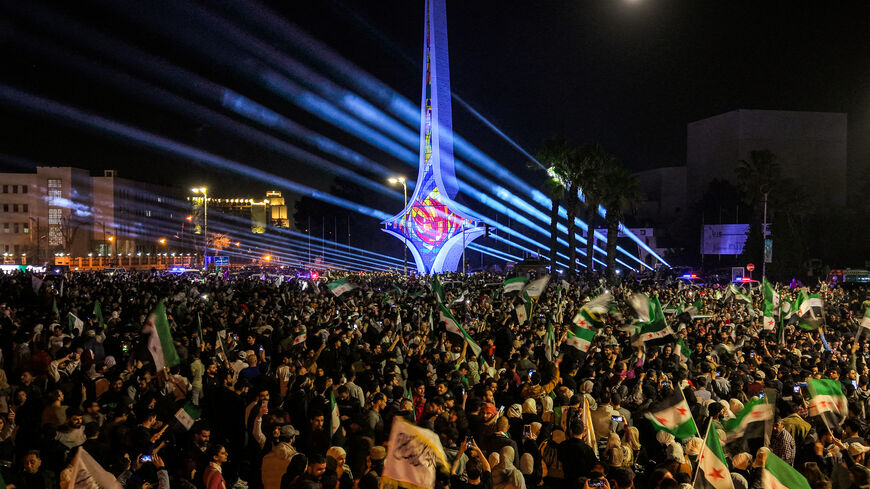 TOPSHOT - This aerial view shows people gathering to commemorate the 14th anniversary of the uprising against Syria's former president Bashar al-Assad for the first time since he was toppled in the Umayyad Square in the centre of Damascus on March 15, 2025. The rally in Damascus was the capital's first after years of repression under Assad, during which the square was the sole preserve of the ousted president's supporters. Activists called on people to hold similar demonstrations in the major cities of Homs