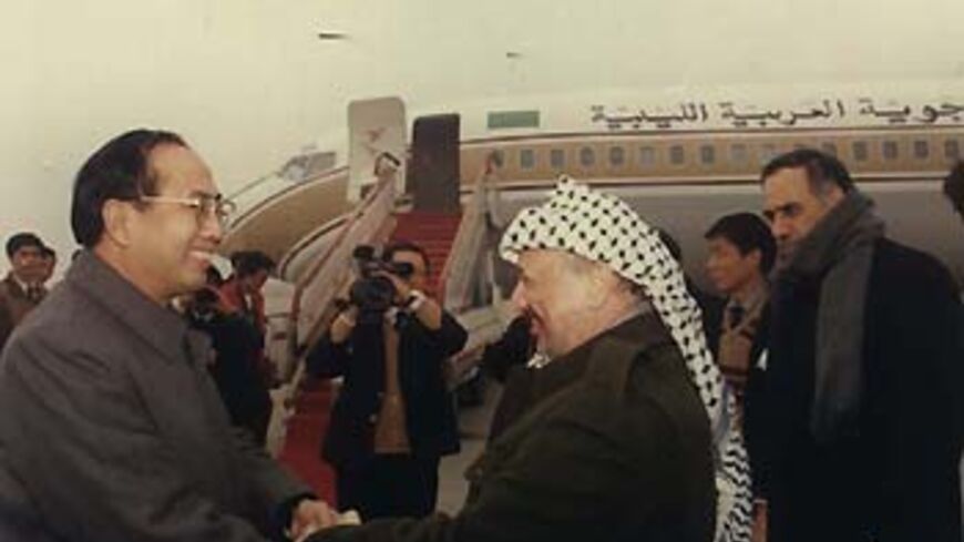 A file photo shows Zhao Qizheng[L], then deputy mayor of Shanghai and current minister of the State Council Information Office, hand in hand with Yasser Arafat in this file photo taken in 1991 at Shanghai's Hongqiao Airport. [China Daily]