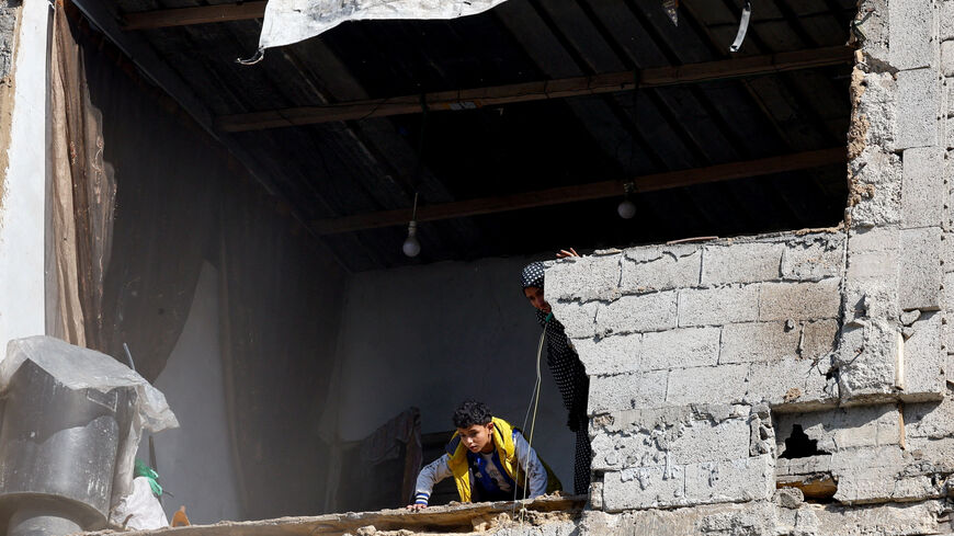 Palestinians look out from a building at the site of a collapsed house that was damaged during the war by an Israeli strike, in the central Gaza Strip, January 5, 2026. REUTERS/Mahmoud Issa