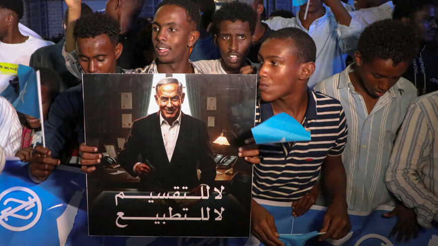 A demonstrator holds an image depicting Israeli Prime Minister Benjamin Netanyahu as Somalis attend a demonstration after Israel became the first country to formally recognise the self-declared Republic of Somaliland as an independent and sovereign state, a decision that could reshape regional dynamics and test Somalia's longstanding opposition to secession, in Hodan district of Mogadishu, Somalia, December 28, 2025. REUTERS/Feisal Omar
