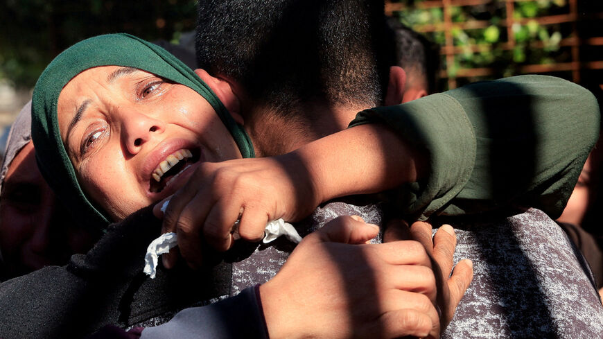 Mourners hug each other during the funeral of Palestinians who, according to medics, were killed in an Israeli strike on Sunday, at Nasser Hospital in Khan Younis, southern Gaza Strip, January 11, 2026. REUTERS/Haseeb Alwazeer