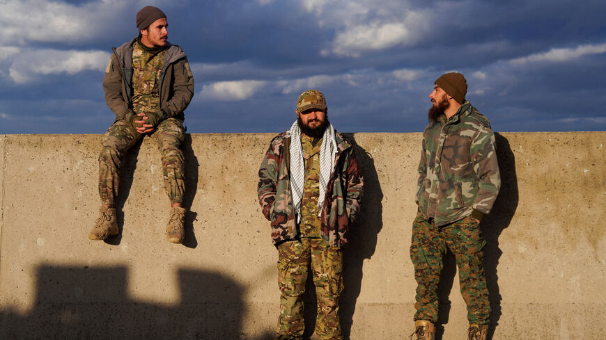 Members of the Syrian army stand together, as Syrian state agency, SANA, reported on Wednesday that the Syrian army sent reinforcements from Latakia to "Deir Hafer front", amid escalating tensions and threats from the Syrian government to launch an offensive against Kurdish-led Syrian Democratic Forces (SDF), in Latakia, Syria, January 14, 2026. REUTERS/Karam al-Masri