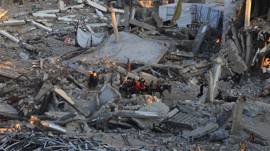 Palestinians move past the rubble of residential buildings destroyed during the war, in Gaza City, January 16, 2026. REUTERS/Dawoud Abu Alkas/File Photo