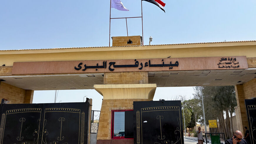 People stand at the Rafah border crossing between Egypt and the Gaza Strip, in Rafah, Egypt, August 11, 2025. REUTERS/Alexander Dziadosz