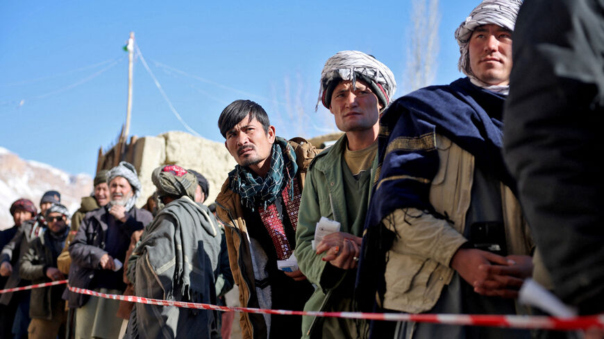 FILE PHOTO: Afghan men wait in line to receive food from a World Food Programme (WFP) distribution center in Yakawlang, Bamyan province, Afghanistan, January 1, 2026. REUTERS/Sayed Hassib/File Photo