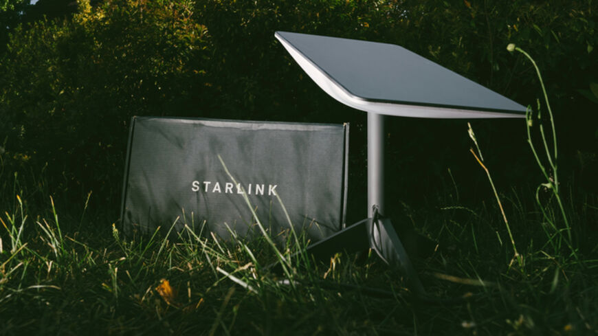 Germany - Jun 16, 2023: Cardboard parcel in backyard at night. Flash photography, no people. Is it a SpaceX Starlink delivery, setting up communication anywhere, even in wilderness spots