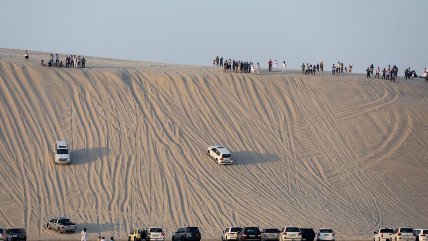 People spend time in the sealine desert south of Doha, Qatar, on November 1, 2024. (KARIM JAAFAR/AFP via Getty Images)
