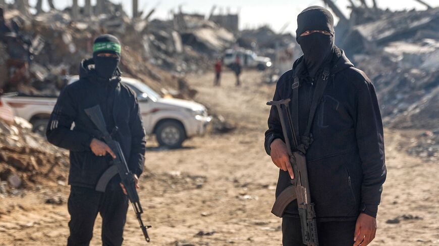 Palestinian Hamas militants secure the area as Egyptian workers, accompanied by members of the International Committee of the Red Cross, search for the last two remaining bodies of hostages from under the rubble of the Jabalia refugee camp, in the northern of Gaza Strip on Dec. 1, 2025. 
