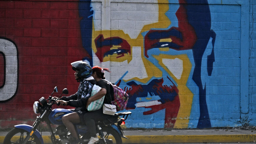 A motorcycle rides past a graffiti depicting President Nicolas Maduro, Caracas, Venezuela, Jan. 3, 2026.