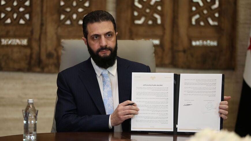 DAMASCUS, SYRIA - JANUARY 18: Syrian President Ahmed Al-Sharaa signs a ceasefire agreement with the Kurdish-led Syrian Democratic Forces (SDF) on January 18, 2026 in Damascus, Syria. According to Syrian state media, the deal includes a handover of Deir ez-Zor and Raqqa governates into government control, and the full integration of SDF fighters into state institutions. It follows the government's recent push towards the key city of Raqqa, after SDF fighters withdrew from Aleppo amid deadly clashes over the 
