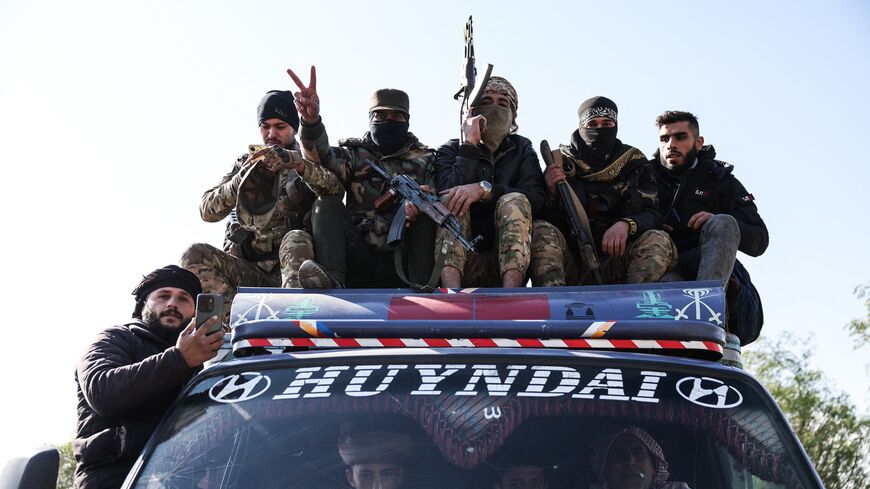 Syrian government forces ride on the roof of a vehicle as they deploy after crossing the Euphrates River in the province of Deir Ezzor, eastern Syria, on Jan. 19, 2026.