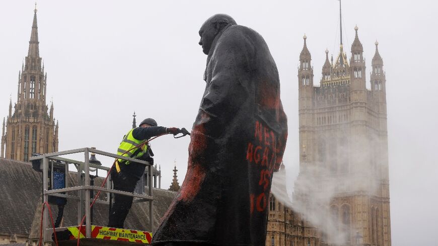 A worker used a pressure hose to clean the graffiti off the statue of Winston Churchill