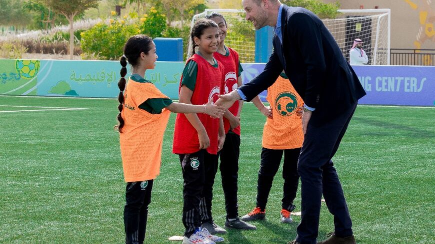 This handout picture released by the Saudi Arabian Football Federation shows Prince William talking to young football players during a training session