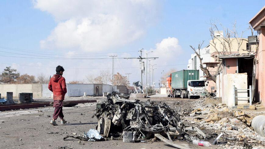 A person walks past the remains of a damaged vehicle at a site, after militant attacks, in Quetta, Pakistan, February 1, 2026. REUTERS/Stringer
