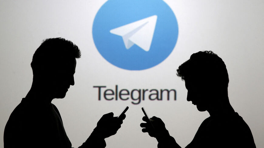 FILE PHOTO: Two men pose with smartphones in front of a screen showing the Telegram logo in this picture illustration taken in Zenica, Bosnia and Herzegovina November 18, 2015.  REUTERS/Dado Ruvic/File Photo