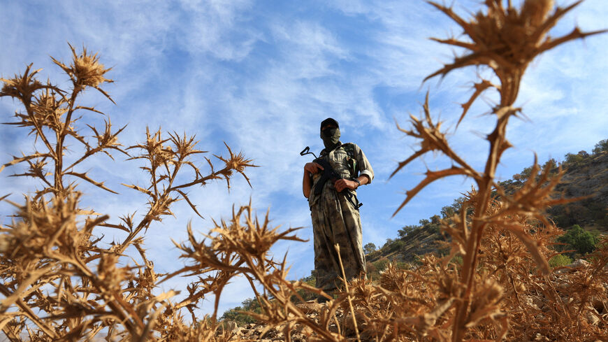 A fighter with the Kurdistan Workers' Party (PKK) stands guard during a disarmament process marking a significant step toward ending the decades-long conflict between Turkey and the outlawed group, in the Qandil mountains, Iraq, October 26, 2025. REUTERS/Thaier Al-Sudani
