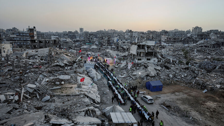 FILE PHOTO: Palestinians gather to break their fast by eating Iftar meals on the first day of the holy month of Ramadan, near the rubble of residential buildings destroyed during the two-year Israeli offensive, in Gaza City, February 18, 2026. REUTERS/Dawoud Abu Alkas/File Photo