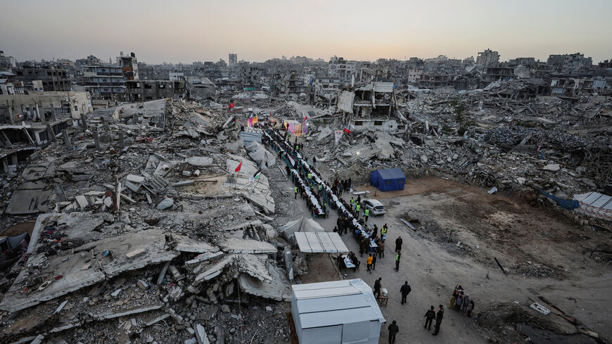 Palestinians gather to break their fast by eating Iftar meals on the first day of the holy month of Ramadan, near the rubble of residential buildings destroyed during the two-year Israeli offensive, in Gaza City, February 18, 2026. REUTERS/Dawoud Abu Alkas