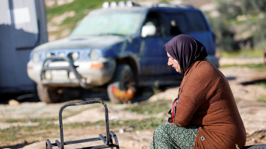 A Palestinian woman sits near a vehicle, which Palestinians say was damaged by Israeli settlers, in Susiya near Hebron in the Israeli-occupied West Bank February 25, 2026. REUTERS/Mussa Qawasma