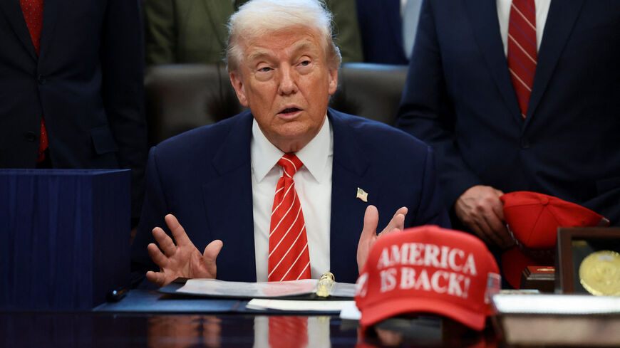 U.S. President Donald Trump sits at his desk, behind a hat that reads "America is back" at the White House in Washington, D.C., U.S., February 3, 2026. REUTERS/Evelyn Hockstein/File Photo