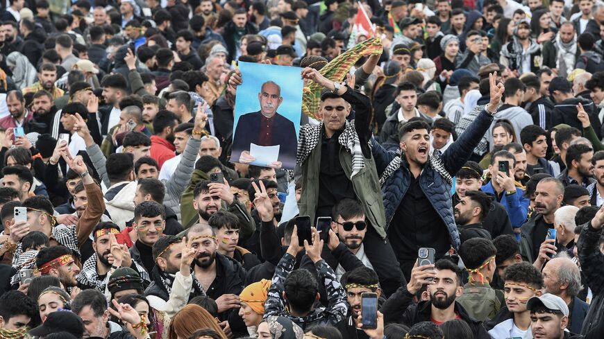 A man holds a poster of Abdullah Ocalan, Turkish-jailed founder of the Kurdistan Workers Party (PKK), during a gathering of Turkish Kurds for Nowruz celebrations in Diyarbakir, southeast Turkey, on March 21, 2025. 
