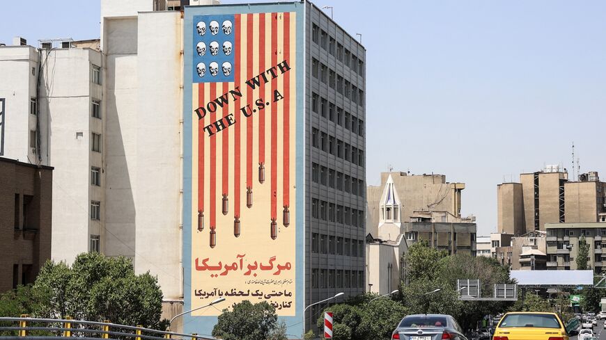 Commuters drive along a bridge near a building bearing a landmark anti-US mural in Tehran, on June 22, 2025. 
