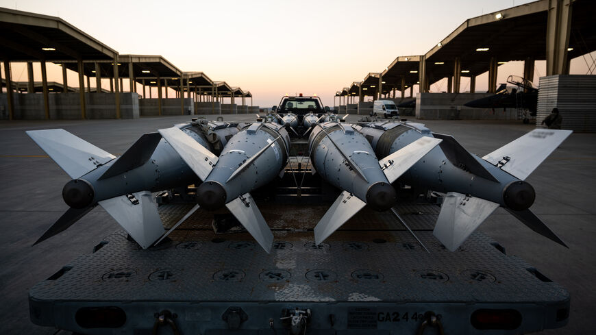 In this handout photo in an undisclosed location, US Airmen prepare to load GBU-31 munition systems onto F-15E Strike Eagles within the US Central Command area of responsibility, Dec. 18, in support of Operation Hawkeye Strike. 