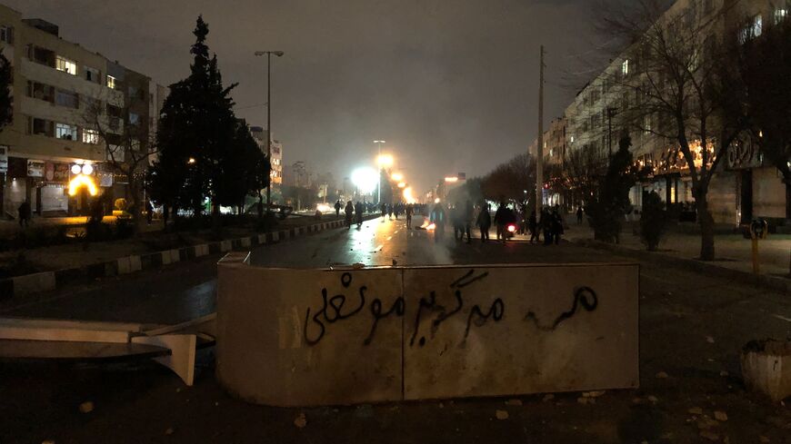 Iranian protesters block a street as a slogan against Iran's supreme leader is spray-painted nearby during a demonstration in Shiraz, Iran, on Jan. 10, 2026. 