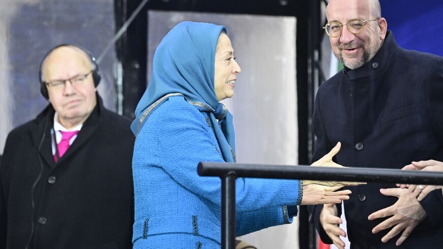 At the demonstration by the MEK, the group's leader Maryam Rajavi (C) welcomed former European Council chief Charles Michel (R) and former German economy minister Peter Altmaier on stage