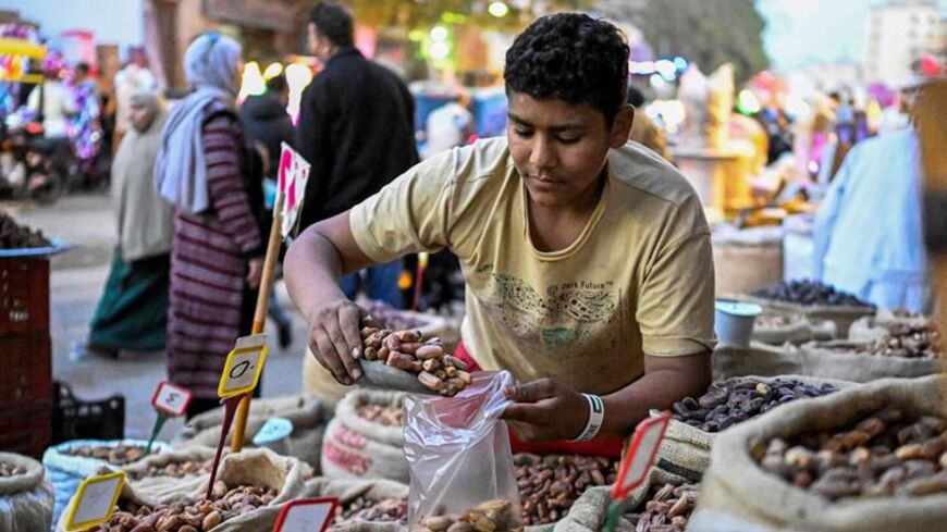 An Egyptian vendor fills dates for a customer at a market in Cairo's central Sayyida Zeinab district on Feb. 12, 2026, as Muslims prepare for the holy fasting month of Ramadan, which begins early next week. — Khaled DESOUKI / AFP via Getty Images