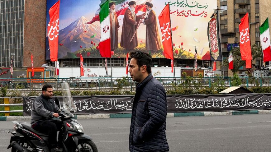 A billboard showing Mojtaba Khamenei receiving the national flag from his father, watched over by founder Ruhollah Khomeini 